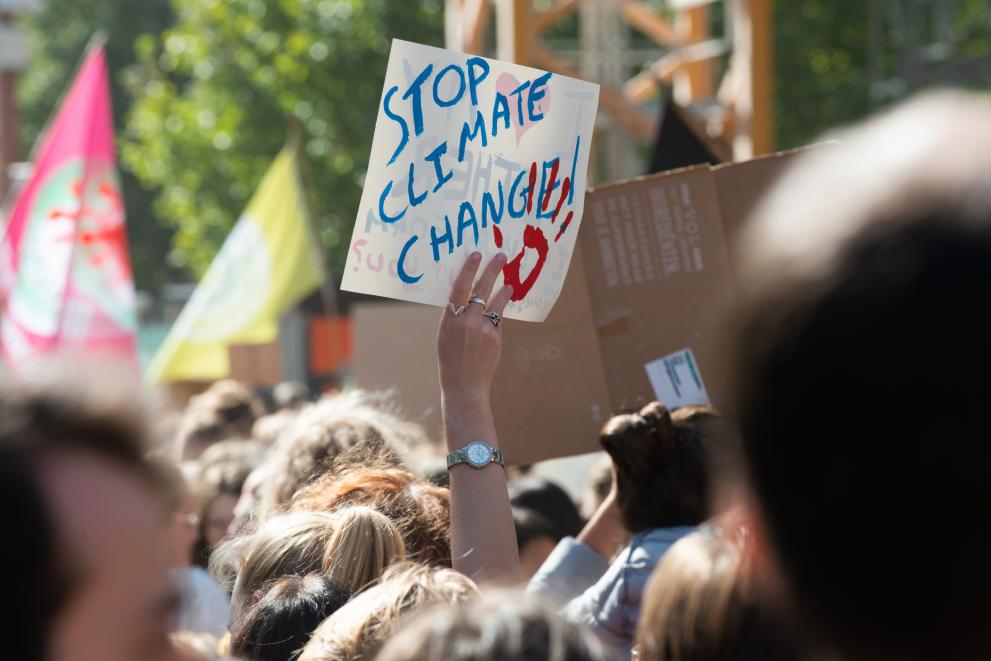   Pancarte avec l'inscription : "Stop climate change" (« Stop au changement climatique »), et la foule de manifestants
