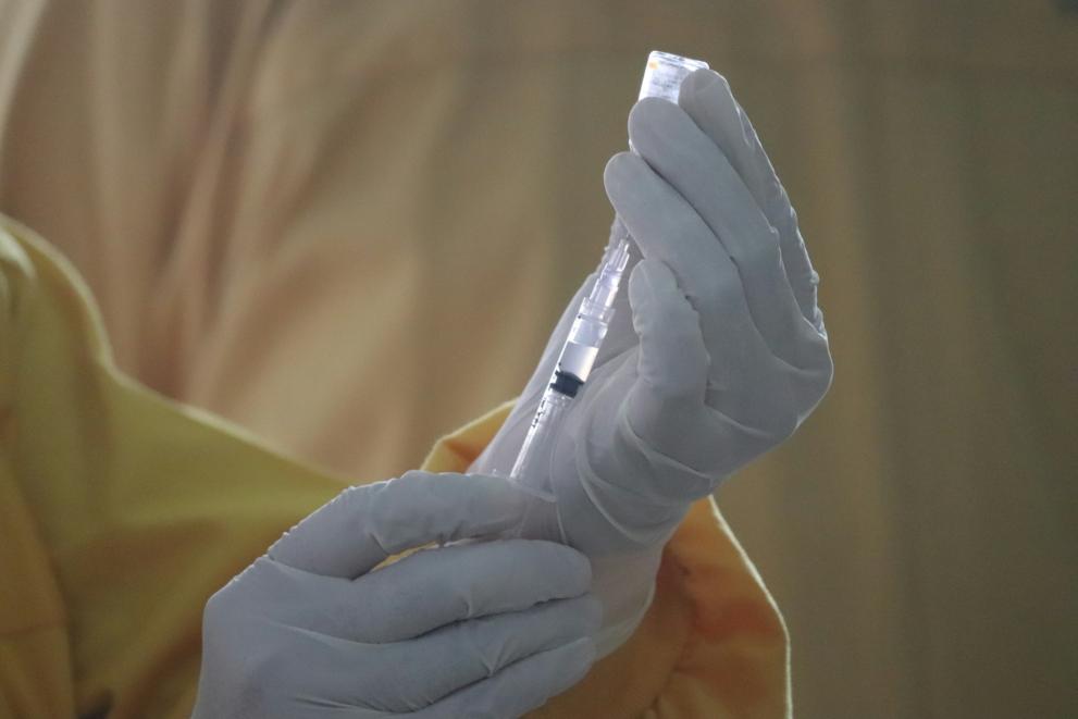 a person holding a vial of vaccine